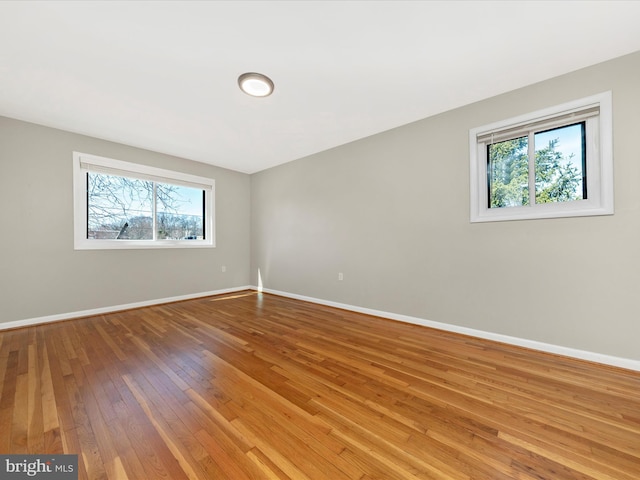 empty room featuring hardwood / wood-style floors and baseboards