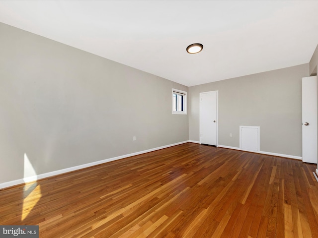 empty room featuring hardwood / wood-style flooring and baseboards