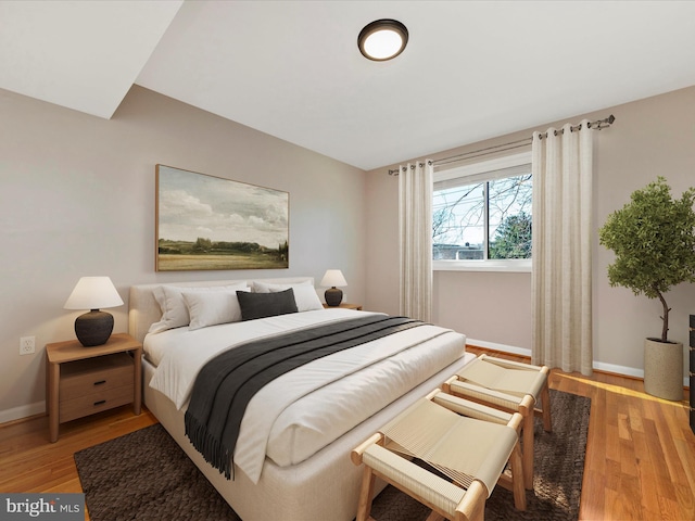 bedroom with baseboards and light wood finished floors