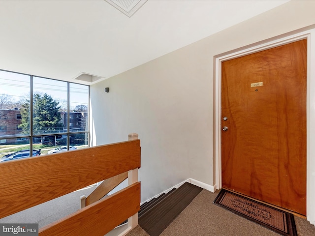 view of exterior entry with visible vents and a balcony