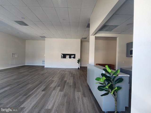 living room featuring a drop ceiling, dark wood-type flooring, and visible vents