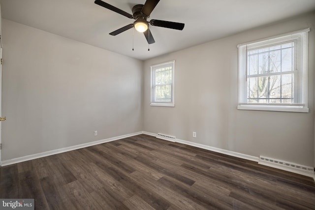 empty room with a ceiling fan, visible vents, baseboards, dark wood-type flooring, and baseboard heating