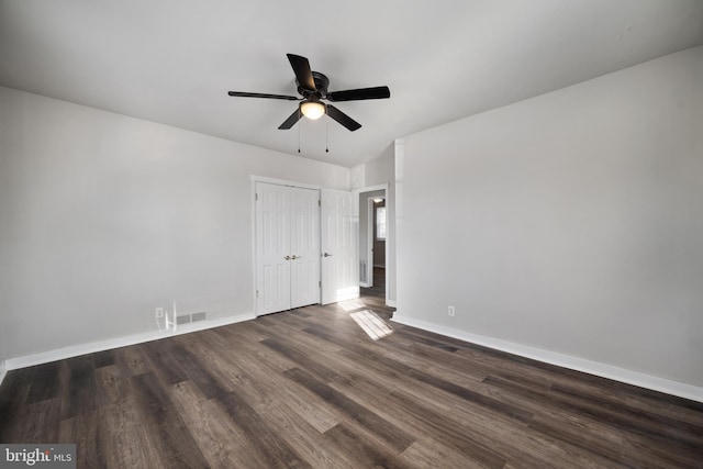 unfurnished bedroom featuring a ceiling fan, wood finished floors, visible vents, baseboards, and a closet