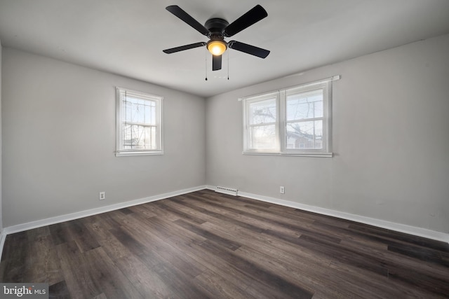 spare room featuring ceiling fan, visible vents, baseboards, and dark wood finished floors