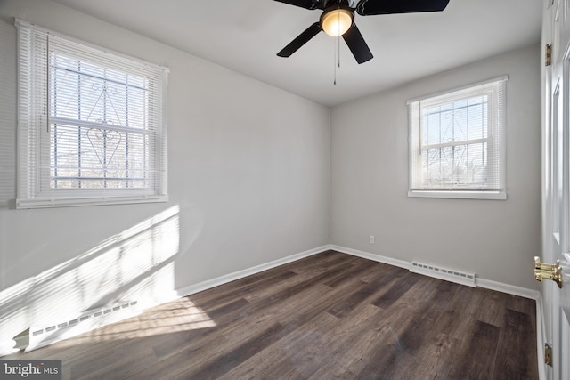 unfurnished room with visible vents, plenty of natural light, dark wood-style floors, and baseboards