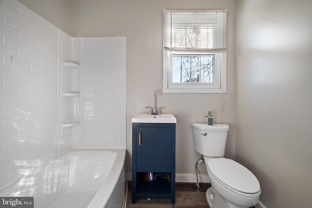 full bathroom with toilet, wood finished floors, baseboards, and a sink