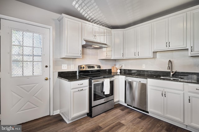 kitchen with a sink, dark wood-type flooring, under cabinet range hood, appliances with stainless steel finishes, and white cabinetry