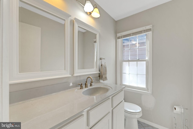 bathroom featuring vanity, toilet, and baseboards