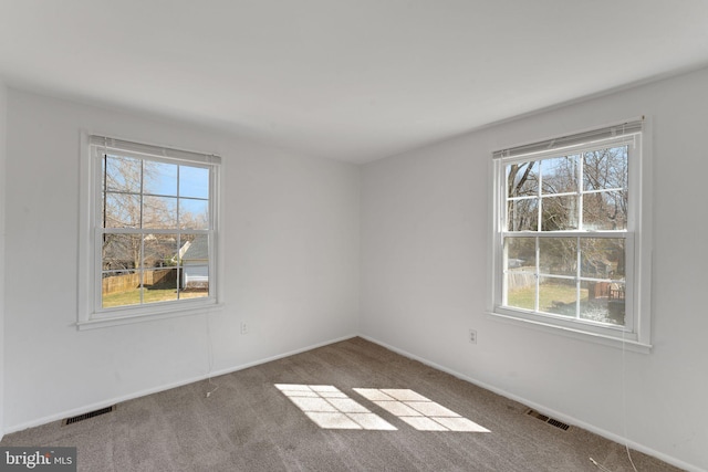 spare room featuring visible vents, baseboards, and carpet flooring