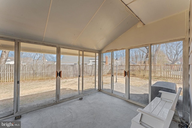 unfurnished sunroom featuring lofted ceiling and plenty of natural light