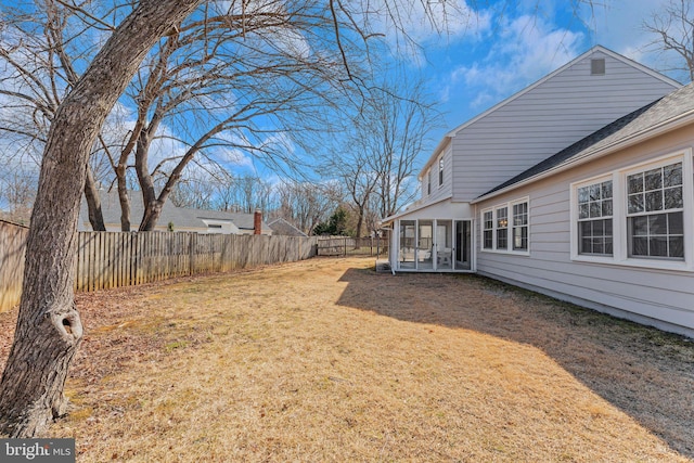 view of yard featuring a fenced backyard and a sunroom