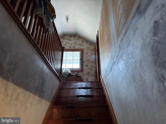 stairs featuring wallpapered walls and vaulted ceiling