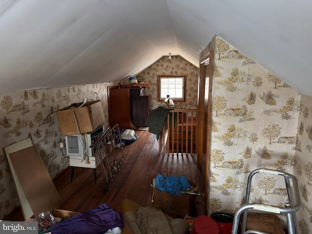 additional living space featuring lofted ceiling, wood finished floors, and wallpapered walls