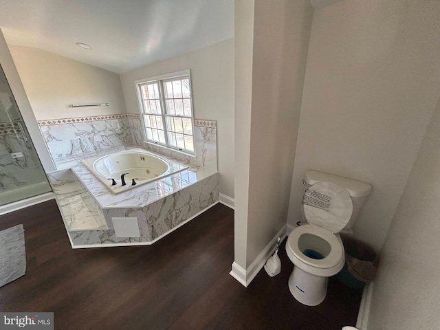 full bathroom with baseboards, a jetted tub, wood finished floors, and vaulted ceiling