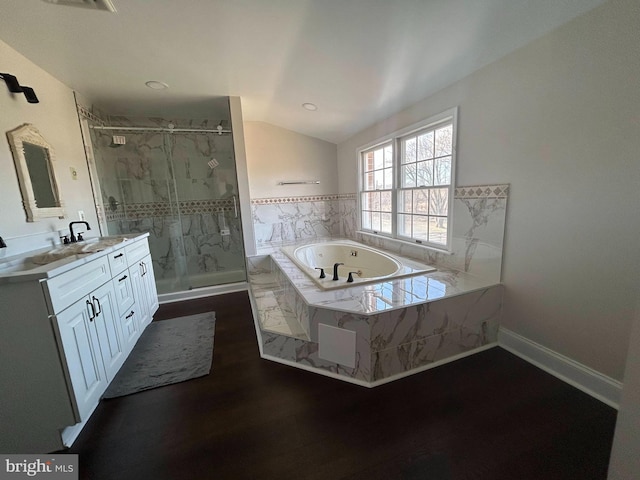 full bath with a marble finish shower, lofted ceiling, wood finished floors, a bath, and vanity