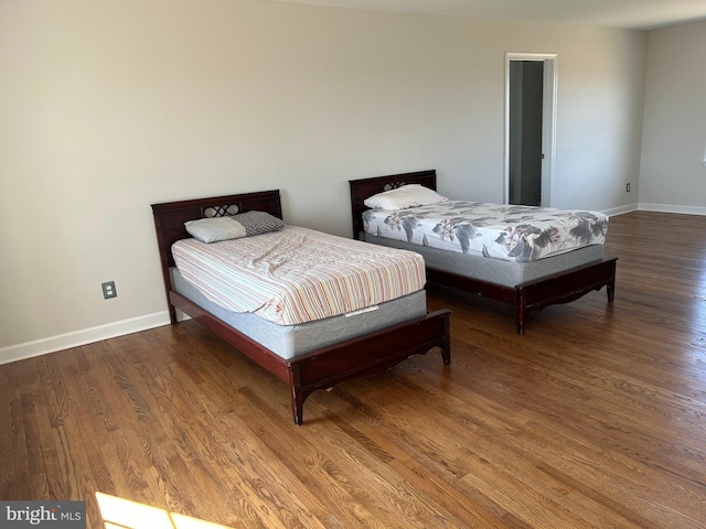 bedroom with baseboards and wood finished floors