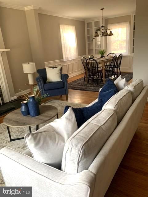 living room featuring a fireplace, wood finished floors, and ornamental molding