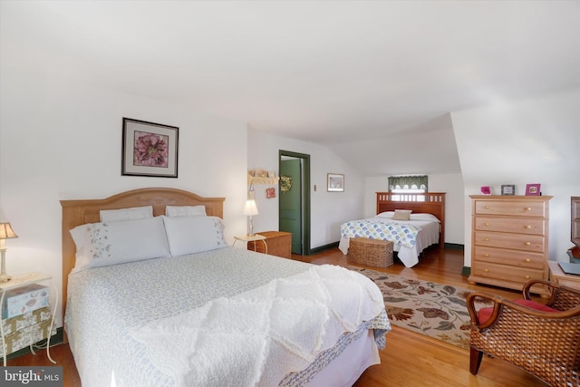 bedroom featuring wood finished floors and vaulted ceiling