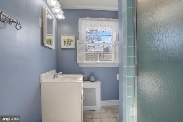 bathroom with vanity, baseboards, and a shower with door