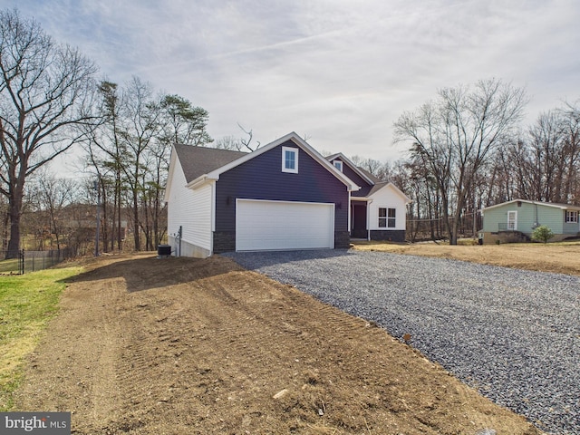 view of front of property featuring fence, a garage, and driveway