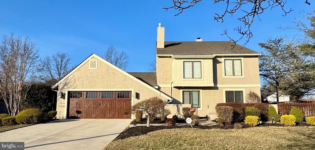 traditional-style home with stucco siding, driveway, an attached garage, a shingled roof, and a chimney