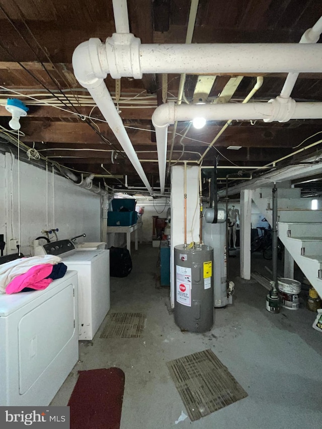 unfinished below grade area with water heater, electric water heater, and separate washer and dryer