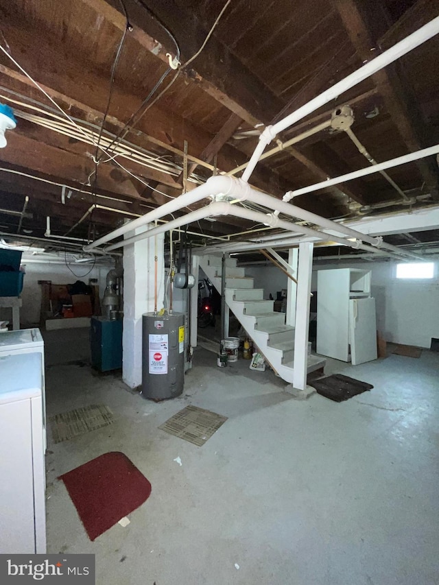 basement featuring stairway, electric water heater, and washer / dryer