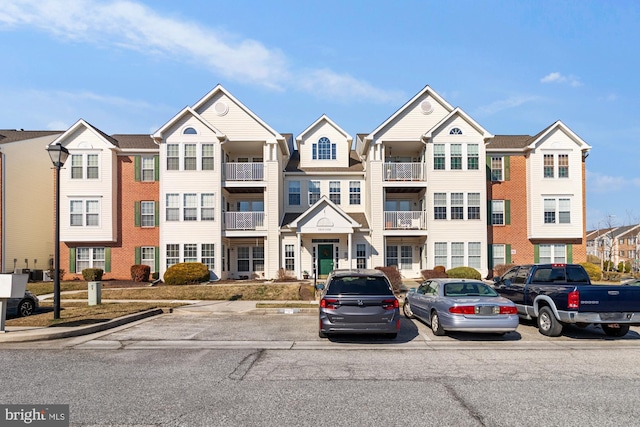 view of building exterior featuring a residential view and uncovered parking