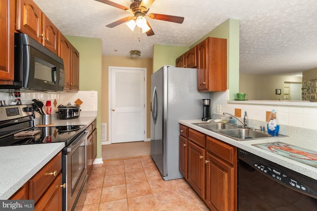 kitchen featuring tasteful backsplash, black appliances, light countertops, and a sink