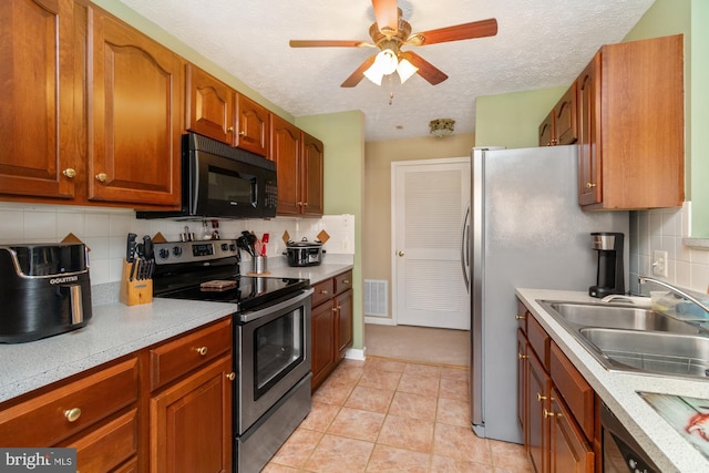 kitchen with visible vents, light tile patterned flooring, a sink, light countertops, and appliances with stainless steel finishes