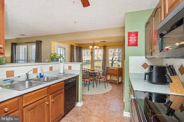 kitchen featuring a healthy amount of sunlight, a sink, light countertops, dishwasher, and stainless steel microwave