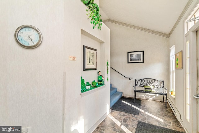 foyer with baseboards, lofted ceiling, stairs, and stone finish floor