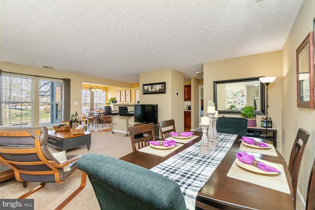 dining area featuring baseboards, a textured ceiling, an inviting chandelier, and carpet floors