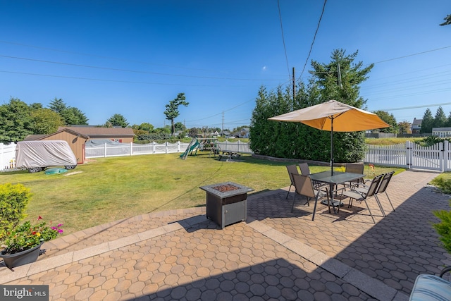 view of patio with an outdoor fire pit, a fenced backyard, and a playground