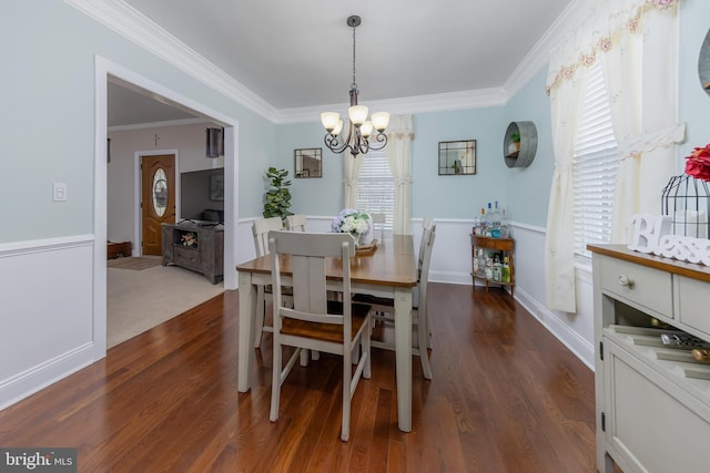 dining area with a chandelier, dark wood-type flooring, and ornamental molding