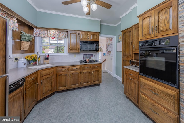 kitchen featuring backsplash, brown cabinetry, black appliances, a ceiling fan, and a sink