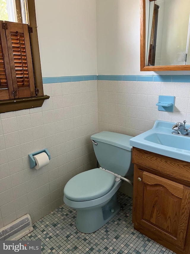 half bath featuring tile patterned flooring, visible vents, toilet, wainscoting, and vanity