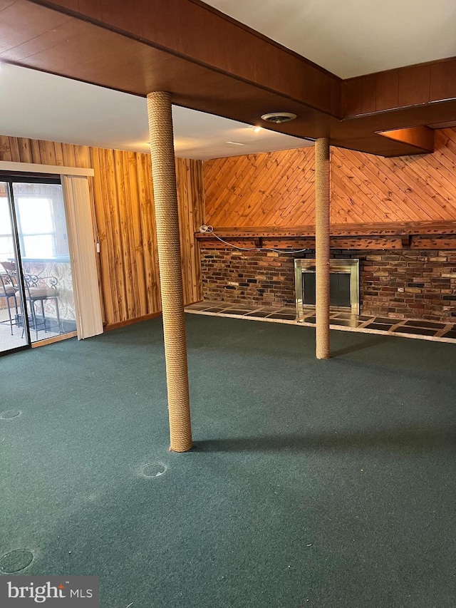 basement with wooden walls, carpet flooring, and brick wall