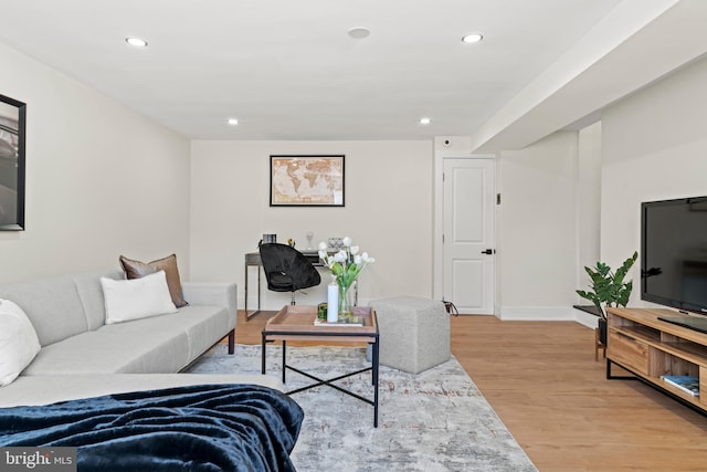 living room featuring recessed lighting, baseboards, and light wood finished floors