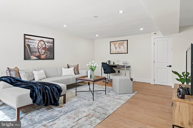 living room with recessed lighting, baseboards, and light wood finished floors