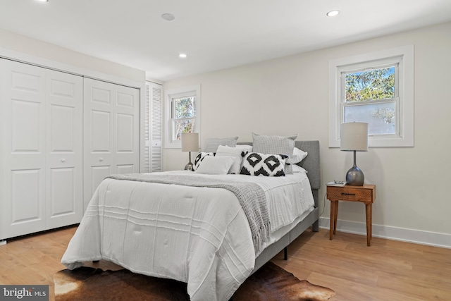 bedroom featuring a closet, recessed lighting, baseboards, and wood finished floors