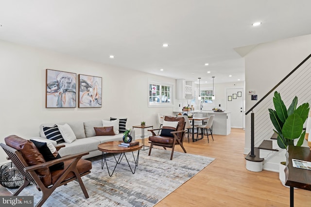 living room featuring stairs, recessed lighting, and light wood-type flooring