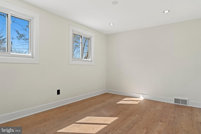 unfurnished room featuring a wealth of natural light, visible vents, and baseboards