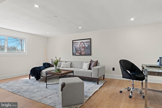 living room featuring recessed lighting, baseboards, and light wood finished floors