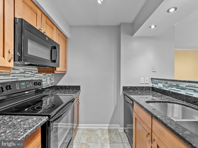 kitchen with decorative backsplash, black appliances, dark stone counters, and a sink