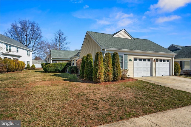 view of side of property with an attached garage, a yard, driveway, and a shingled roof