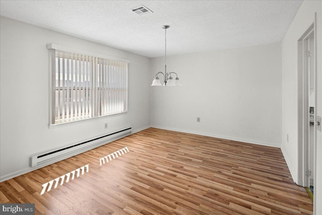 unfurnished dining area featuring visible vents, an inviting chandelier, wood finished floors, a textured ceiling, and a baseboard radiator