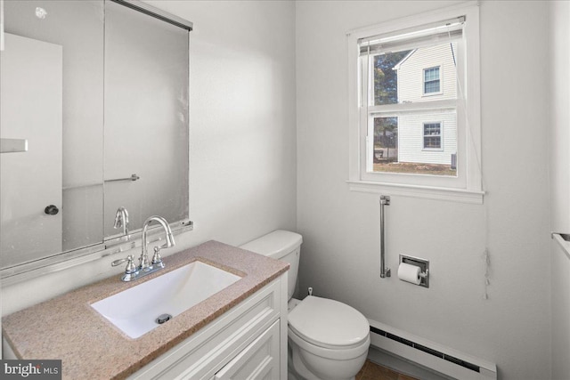 half bathroom with a baseboard radiator, toilet, and vanity