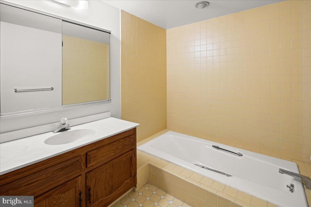 full bathroom with tiled bath and vanity