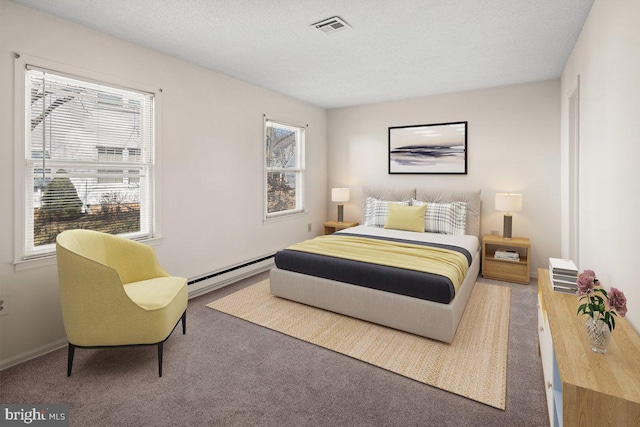 bedroom with a baseboard heating unit, carpet, visible vents, and a textured ceiling